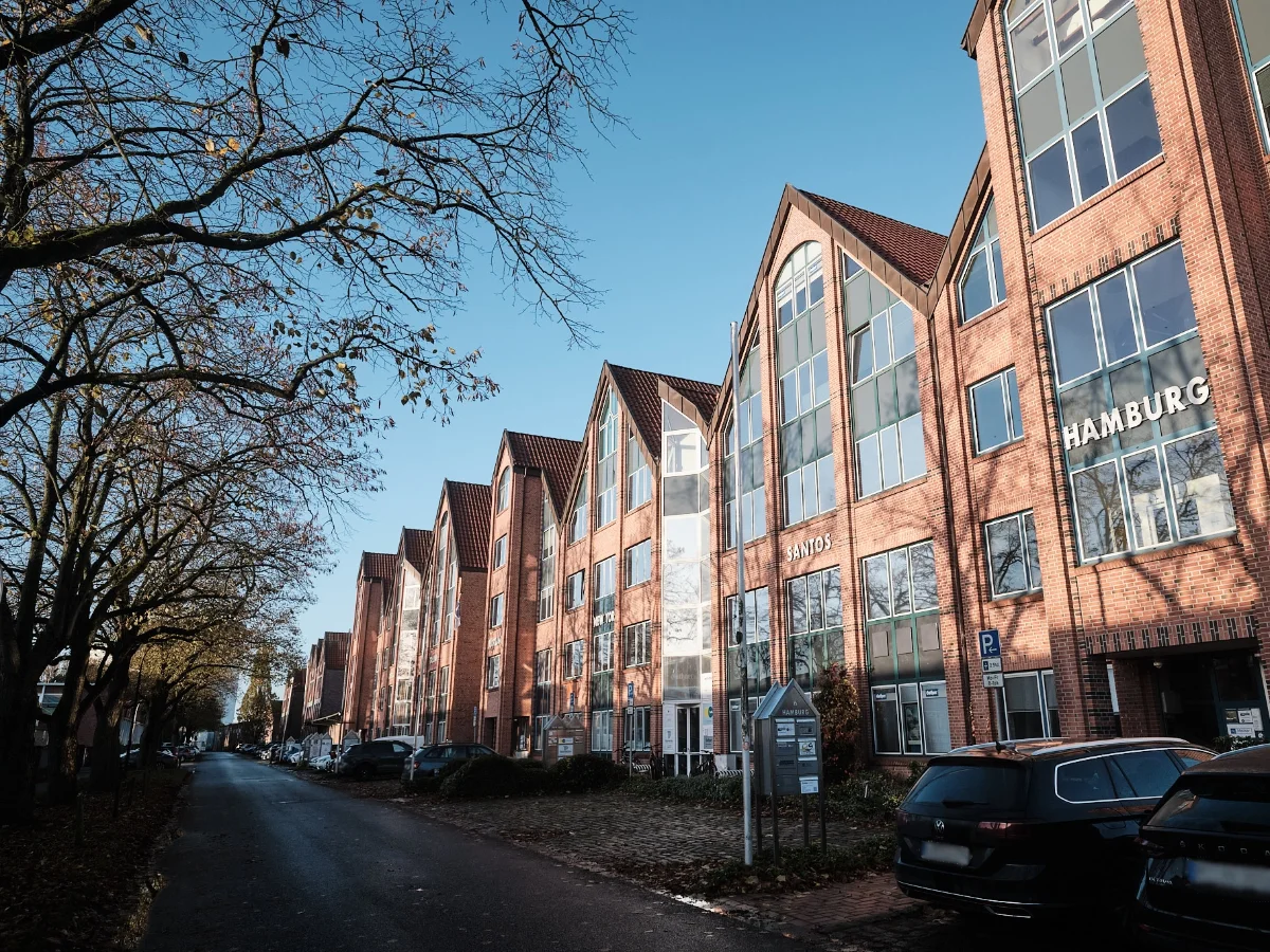 Standort Hamburg – Bürogebäude der wemotion Digitalagentur Moderne Bürogebäude aus rotem Klinker in Hamburg bei blauem Himmel – Standort und Arbeitsumfeld der wemotion Digitalagentur.