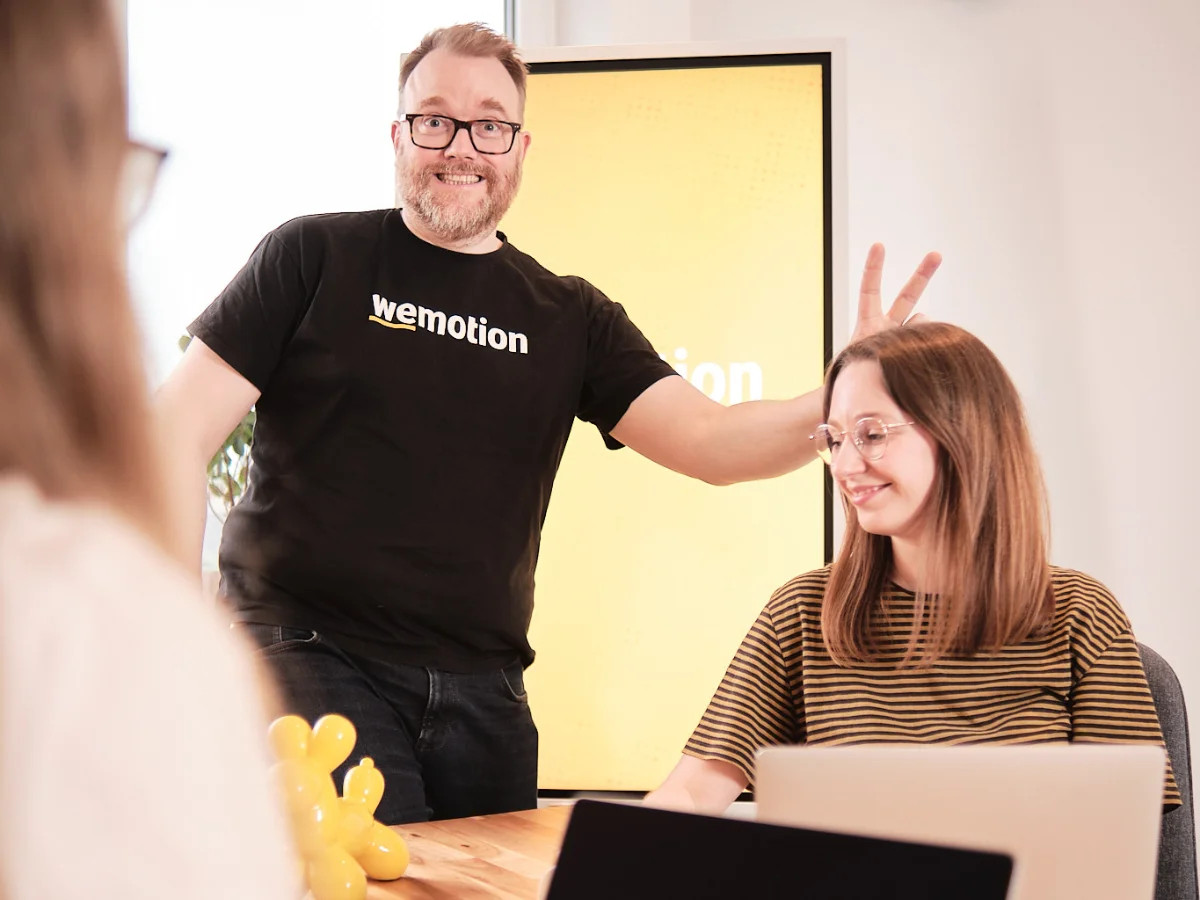 Humor und Teamkultur – gemeinsames Arbeiten bei der wemotion Digitalagentur Teammitglieder der wemotion Digitalagentur lachen gemeinsam während einer Besprechung – Symbol für Humor und positive Teamkultur.