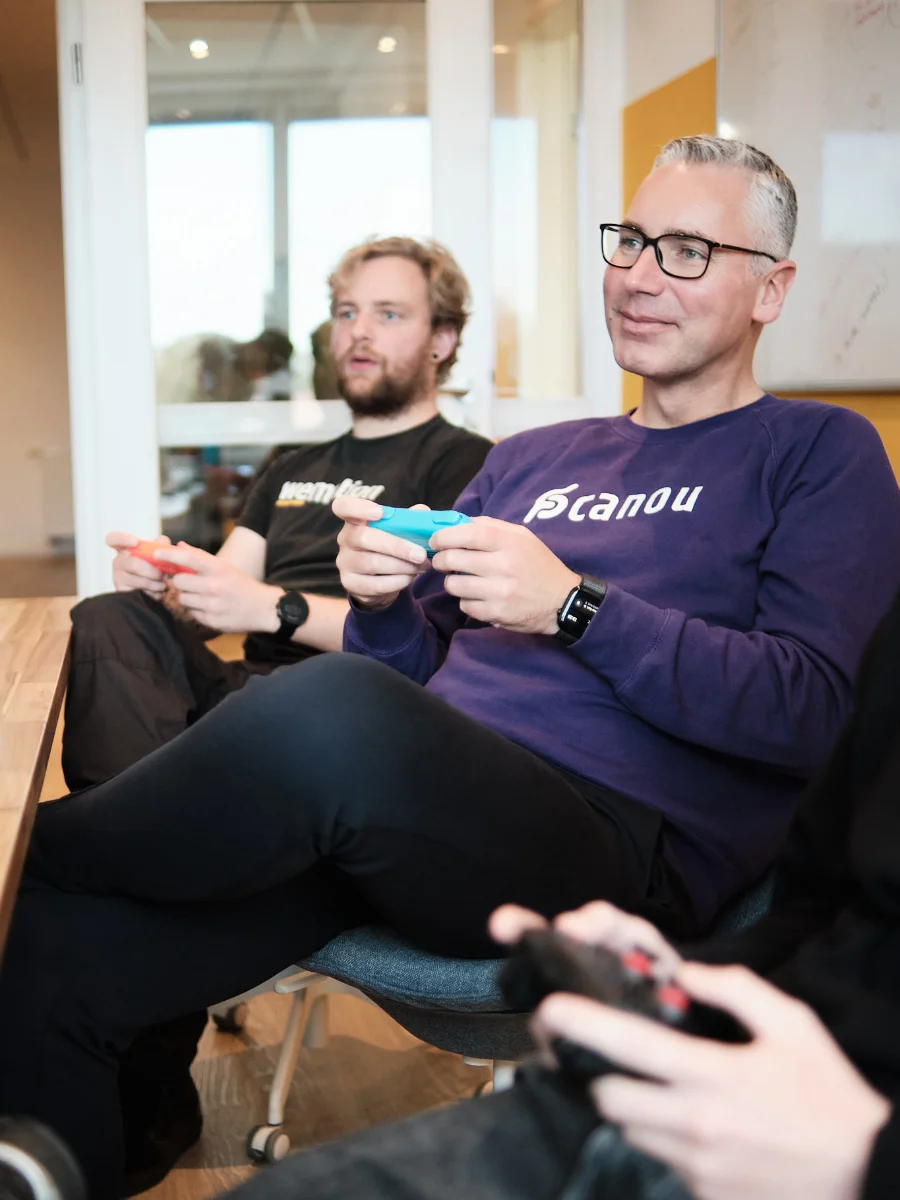 Teamgeist und Spaß bei der Arbeit – Spielpause bei wemotion Teammitglieder der wemotion Digitalagentur machen eine gemeinsame Videospielpause im Büro – Symbol für Teamgeist und entspannte Arbeitsatmosphäre.