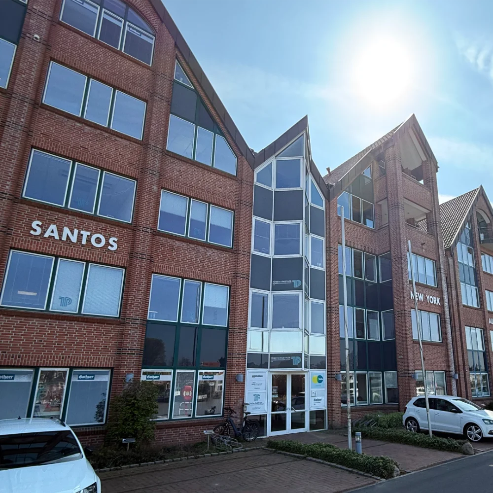 Außenansicht: Klinkerbürogebäude am wemotion-Standort bei Sonnenschein.